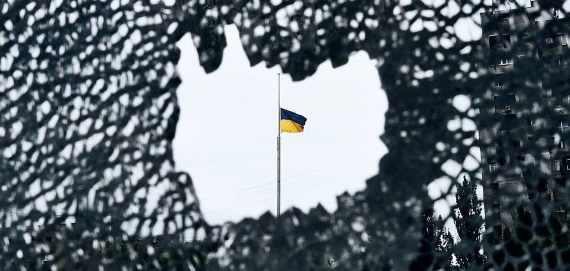 Ілюстративне фото. Прапор України на фоні маскувальної сітки