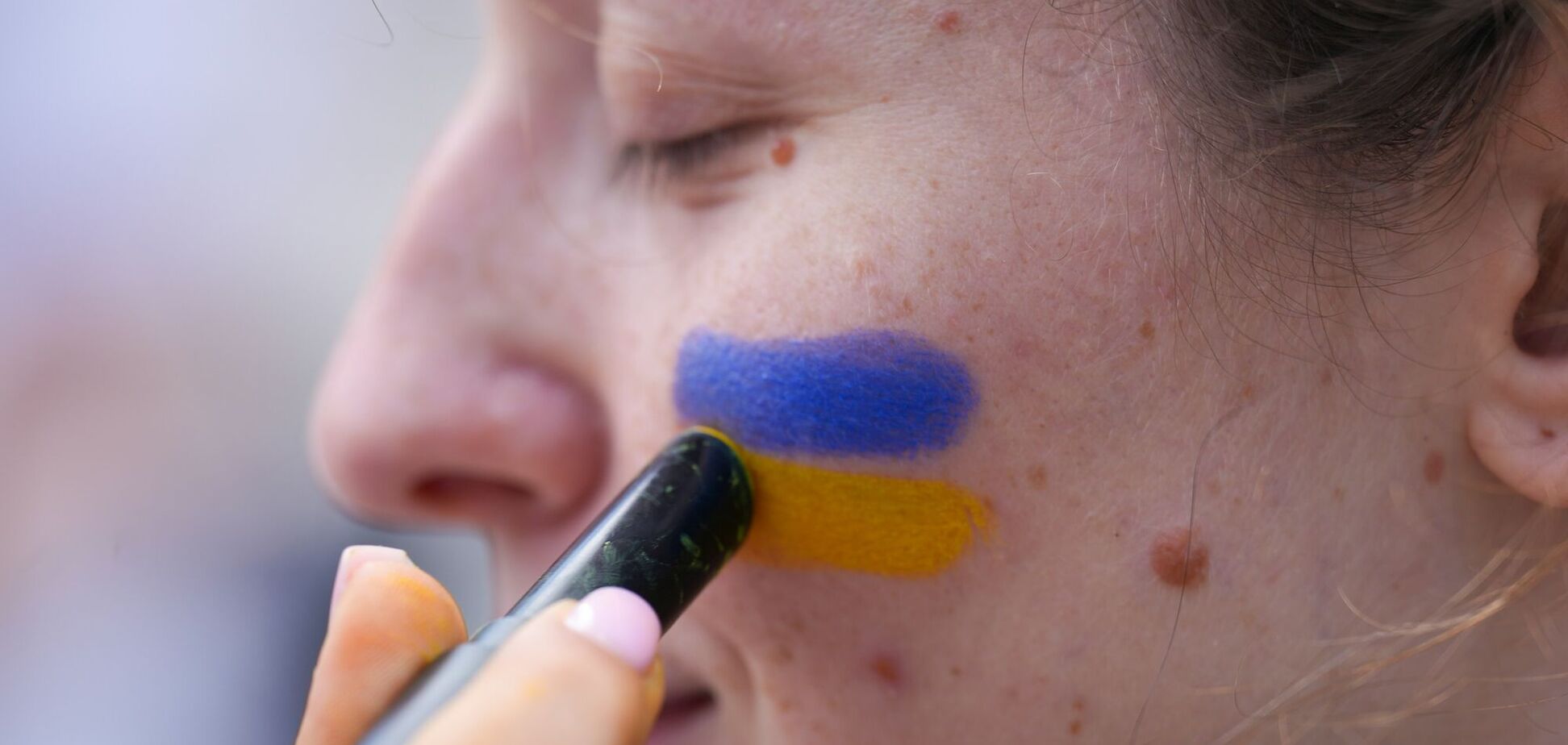 Ілюстрація - жінці наносять на обличчя кольори прапору України