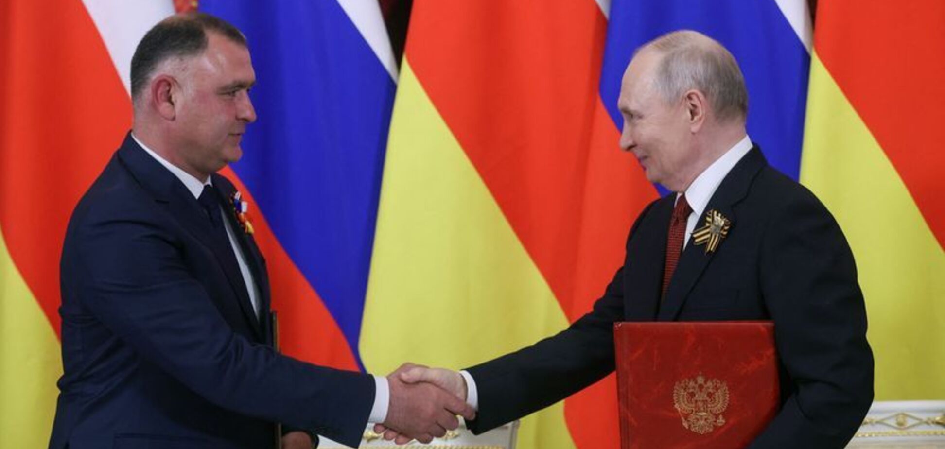 Президент Росії Володимир Путін (праворуч) і Алан Гаглоєв, президент сепаратистського грузинського регіону Південна Осетія, присутні на церемонії підписання документів після зустрічі в Кремлі (Москва, Росія), 9 травня 2026 року